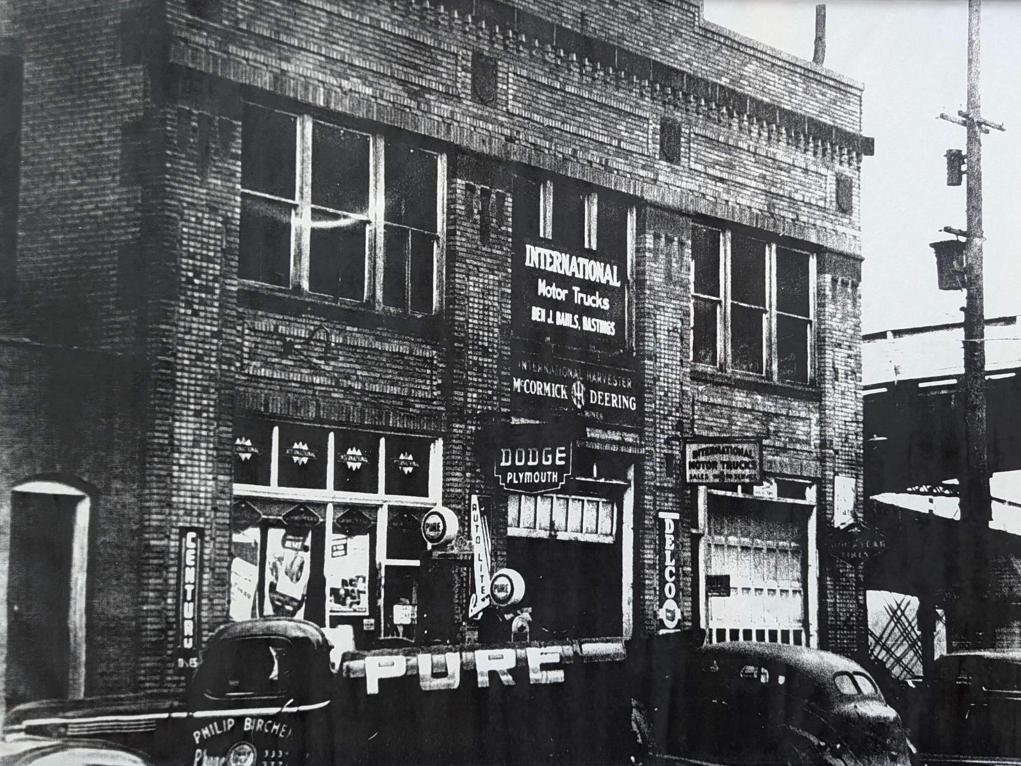 Historic photograph of 100 Sibley with automotive signs and vehicles outside